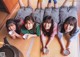 A group of young women laying on the floor with cups of tea.