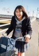 A young woman riding a bike with a backpack on the back.