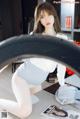 a woman sitting on top of a table next to a car