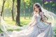 A woman in a wedding dress is walking through the woods.