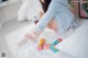 A woman sitting on a bed with a toothbrush in her hand.